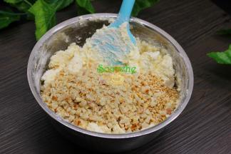 加入擀碎的花生碎、炒熟的白芝麻，继续搅拌均匀。