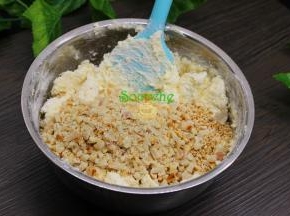 加入擀碎的花生碎、炒熟的白芝麻，继续搅拌均匀。