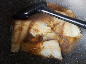 把鱼两面都煎制微黄，倒入料酒，生抽，撒入点白砂糖降咸提鲜，再滴入点米醋，让鱼肉入味。