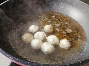 翻炒片刻出香味后，倒入适量清水，鱼丸也放入。
