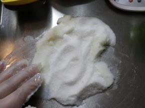 在猪油成为比较溶解的时候，加入细砂糖（如果你的细砂糖不易融化的话，就选择糖粉或者绵白糖），手动搅打，让空气搅打进去，并且让糖跟猪油完全溶解。