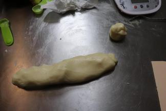 将面团朝着一个方向轻轻的推动，直至成为一个长条。