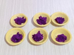 将做好的紫薯泥放入蛋挞皮中，如图。