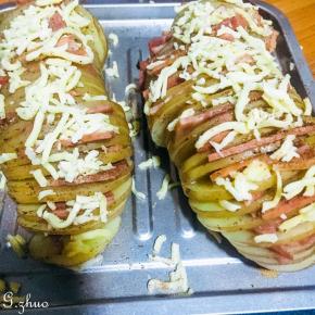 取出烤好的土豆，去除锡纸，每一片之间夹上培根，表面撒上芝士，放进烤箱200度烘烤15分钟即可。