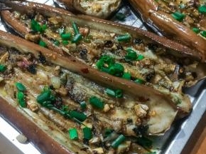 待茄子烤好后，取出中间划开，茄肉部分也可划上几刀方便入味，抹上淹料撒上葱花。，