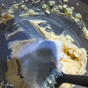 打匀后的黄油过筛加入蛋糕粉，扮匀至看不到干粉的状态，