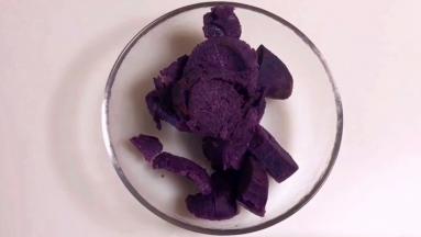 把3个紫薯去皮切块，蒸熟，放入一个大容器中。