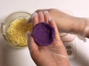 取25克一个的小紫薯团，揉圆按扁，捏成一个小碗的形状