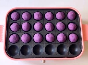 预热好后，把紫薯球放入烤制，因为烤盘是不粘材质，可以不放油，刷一层油也可以。