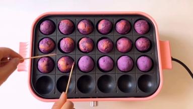 底部上色后，借助竹签翻面，让整个紫薯球表面都烤上。