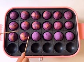 底部上色后，借助竹签翻面，让整个紫薯球表面都烤上。