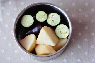把切好的土豆、茄子放进蒸网里面