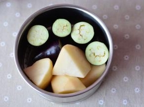 把切好的土豆、茄子放进蒸网里面