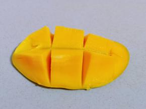 首先将芒果洗干净，从中间切开，再把芒果肉切下来。