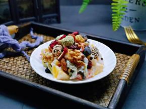 拌好的水果沙拉装盘，再放上三种口味的扁核桃仁。