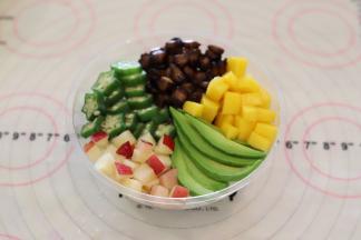 芒果和桃子切成小粒，牛油果和秋葵切片，摆放在白饭上面。