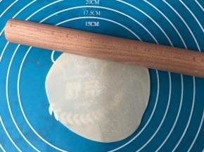 买来的现成的饺子皮用擀面杖擀大一些。