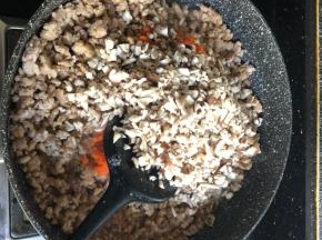 加入胡萝卜和香菇碎，加两勺生抽，少许盐翻炒均匀。