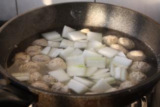 将冬瓜片放入丸子汤中，大火煮开。