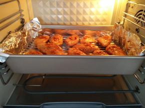 鸡翅摆放在烤盘上，用小勺将两面都浇上料汁。