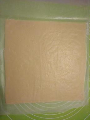 取长度约60厘米的油纸，把油纸对折，用擀面杖把面团大致擀开呈正方形。用油纸包裹好面团，送入冰箱冷藏定型10分钟左右。