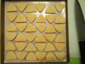 烤箱上下火160度预热。把冷藏定型好的饼干面团切成约0.5厘米厚的片状，平铺在垫了硅胶垫或油布的烤盘上。