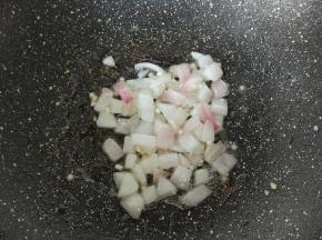 不粘锅再放点油，放蒜末和洋葱，炒至洋葱变透明。