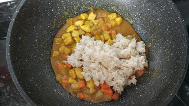 汤汁变浓稠后加入干饭，加味精，翻炒均匀。