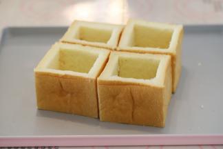 面包刀从吐司内的四周开始切，将中间部分的软心挖出。