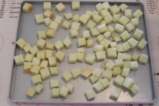 其余的吐司片切成小正方形状，放入烤盘。