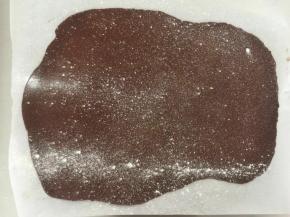 慢慢揭开油纸，撒上薄薄一层低粉，盖上油纸，翻面继续撒粉。