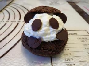 再用淡奶油挤出熊猫的脑袋，插上巧克力片装饰熊猫的脸。