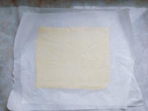 在厨师机揉面的同时，将片状黄油夹在两片油纸中间，擀成均匀的长方形片状，放入冰箱冷冻。