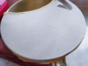 剪一块面团，用手拉扯四周，拉伸出均匀的薄膜，即完全扩展状态即可（不要用手揪面团，以免扯断面筋）。