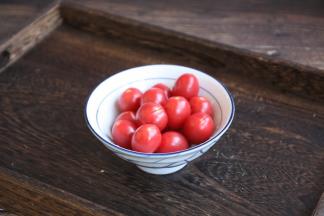 在小番茄的蒂部用小刀划一个小口。