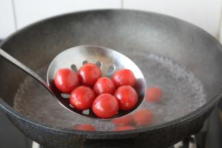 水开后下入小番茄焯水，然后过凉水。
焯水时间一定要短，8秒钟即可。