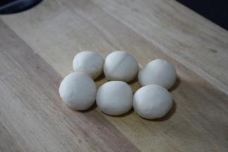 面团醒好后反复揉捏，搓成长条，切成大小均匀的六个小面团，将小面团揉圆盖上保鲜膜醒20分钟。