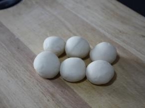 面团醒好后反复揉捏，搓成长条，切成大小均匀的六个小面团，将小面团揉圆盖上保鲜膜醒20分钟。