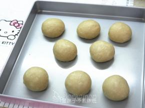 发酵好的面团按压拍打排气，平均分成8个面团，将它们都滚圆之后盖上保鲜膜松弛15分钟。