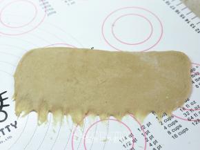 .松弛好的面团压扁，用擀面杖擀成长方形面片。面片的下端记得用手指压扁拉长，这样待会好粘合。