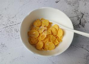 玉米片在牛奶中浸泡一会，用勺子拌一拌，等待片刻。