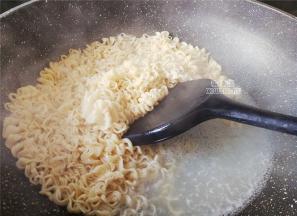 另起一锅倒入冷水煮沸，把2个鸡蛋面饼放入煮软，煮熟（建议用碱水面会更好吃）。