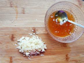 首先鸡中翅洗净划上几刀，把蒜瓣切成蒜蓉，拌入柚子蜂蜜中备用。