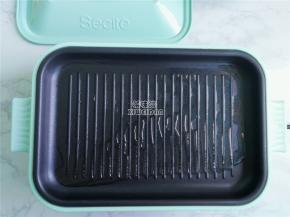 多功能锅装入煎盘，热锅倒入适量的食用油，均匀涂抹开。