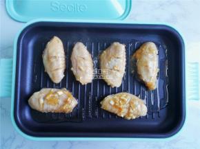 把腌制好的鸡中翅依次摆入煎盘中，进行煎制，盖上盖子热度更高。