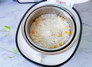 把沥干的混合好的梗米倒入甑子中，用饭铲压压平。