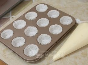 将纸杯套在模具上，蛋糕糊装进裱花袋。