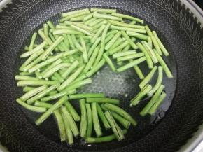 锅里加入适量的水，少许的油和盐，大火烧开，然后把长豆角放入锅中焯熟
