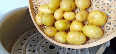 土豆清洗好放高压锅蒸熟。