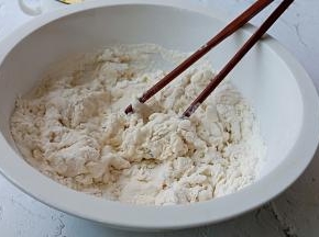 一边倒牛奶一边拌，拌成絮状。